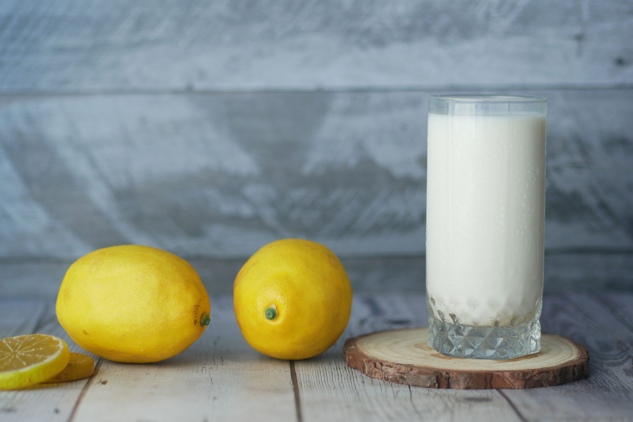 Glass measuring cup with milk and lemon juice being mixed for a homemade buttermilk substitute
