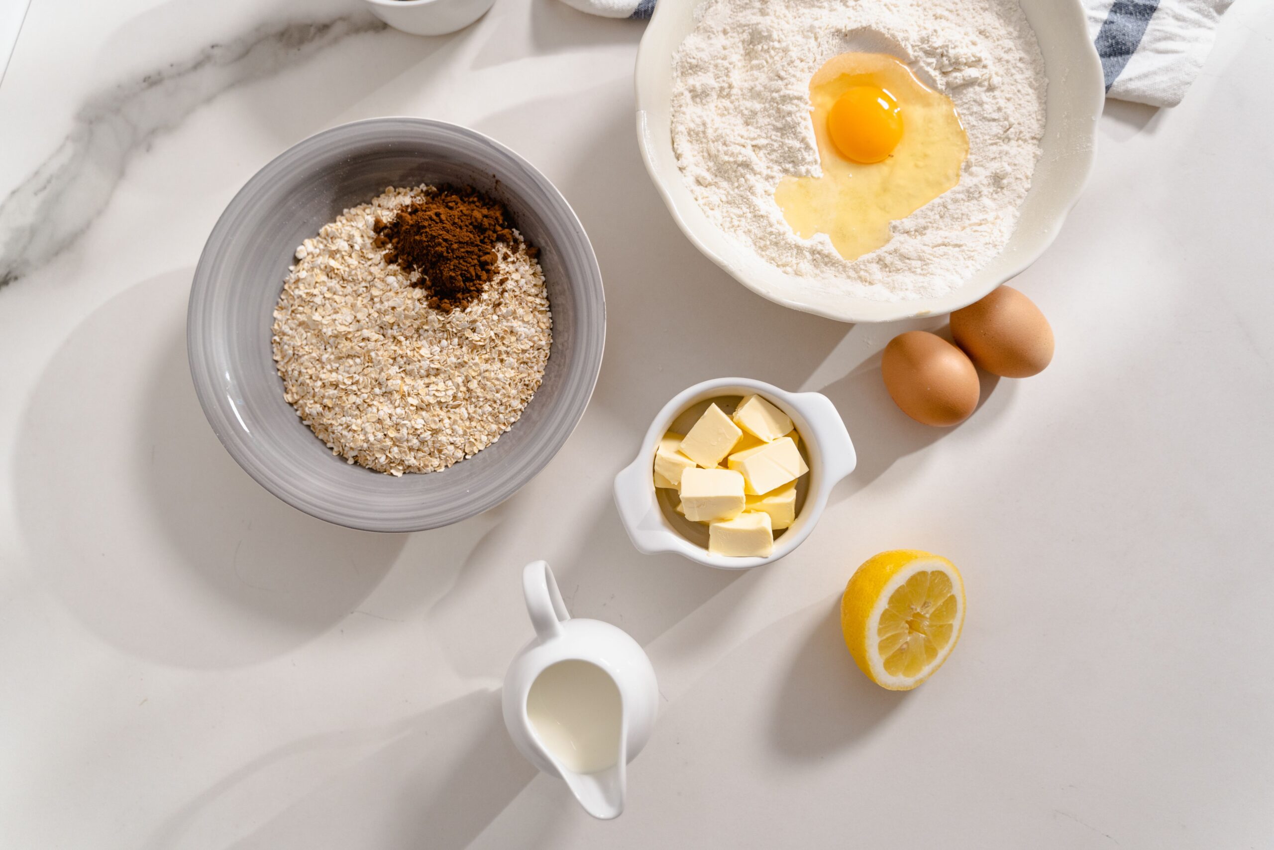 Overhead flat lay of halved baking ingredients and measuring spoons arranged on a kitchen counter