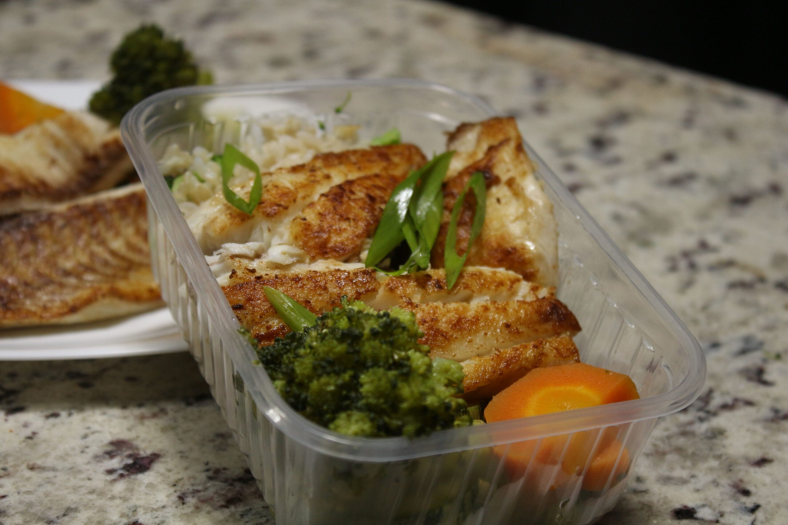 Cooked chicken portions stored in airtight meal prep containers ready for refrigeration