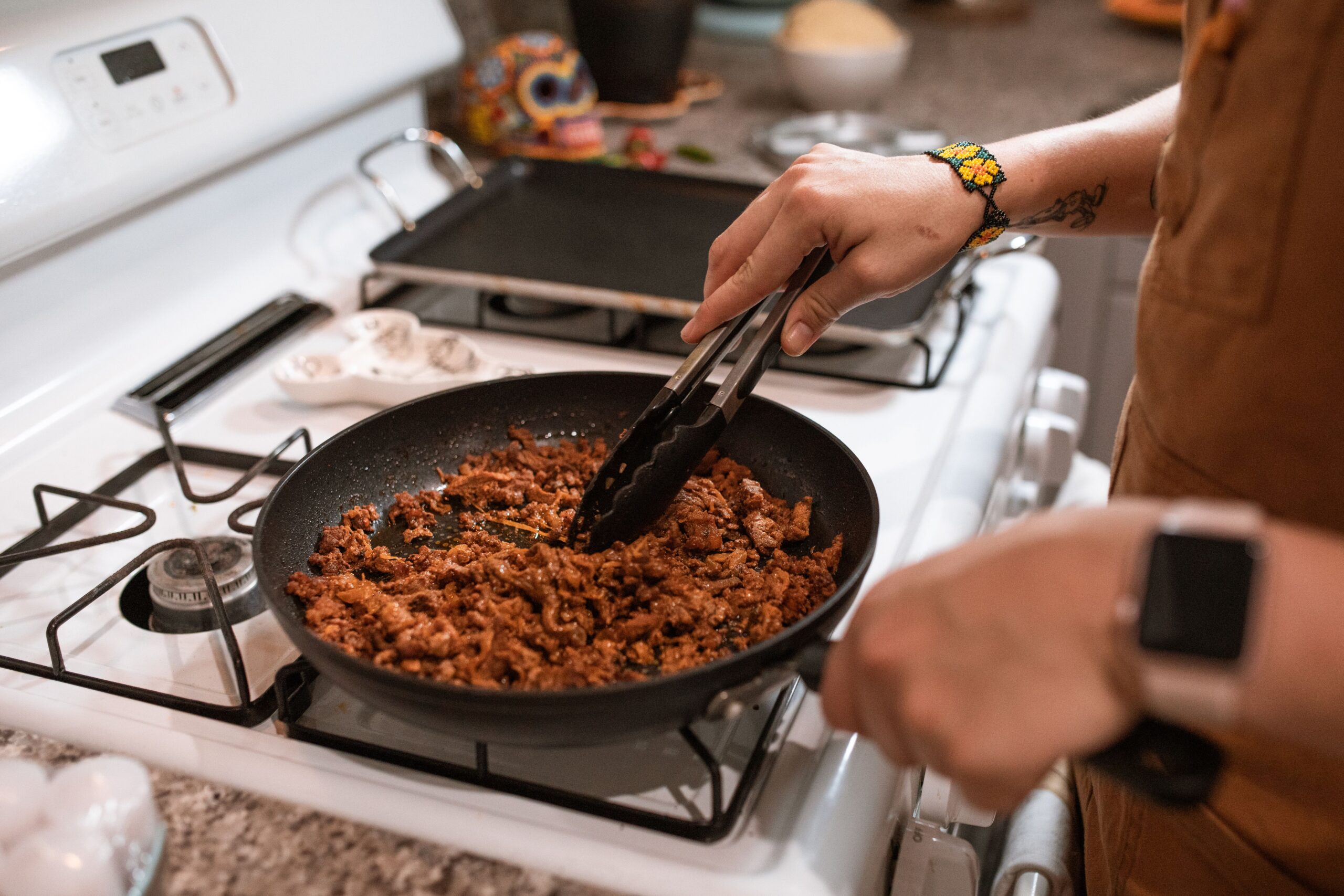 Ground beef browning in a skillet on the stovetop, showing proper cooking to a safe internal temperature