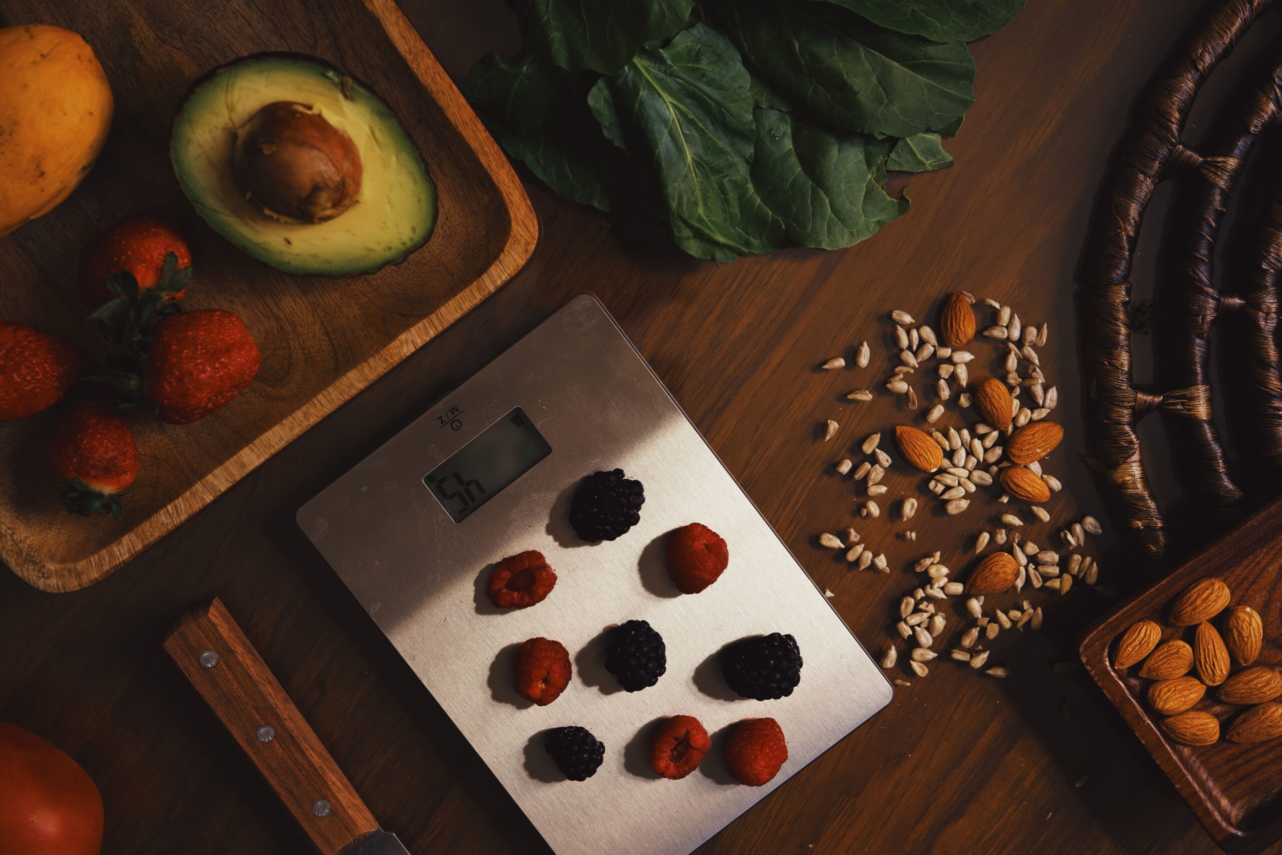 Digital kitchen scale next to nested measuring cups on a marble counter with flour and sugar, overhead flat-lay
