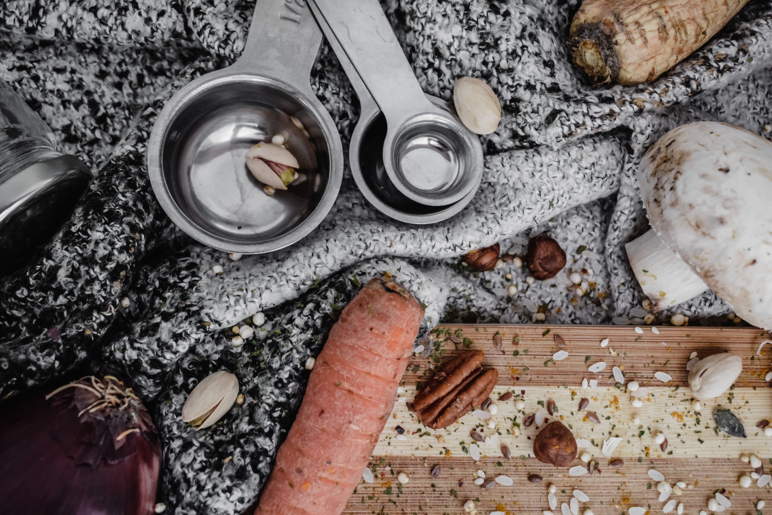 Measuring spoons and measuring cups arranged in a flat lay on a light kitchen surface