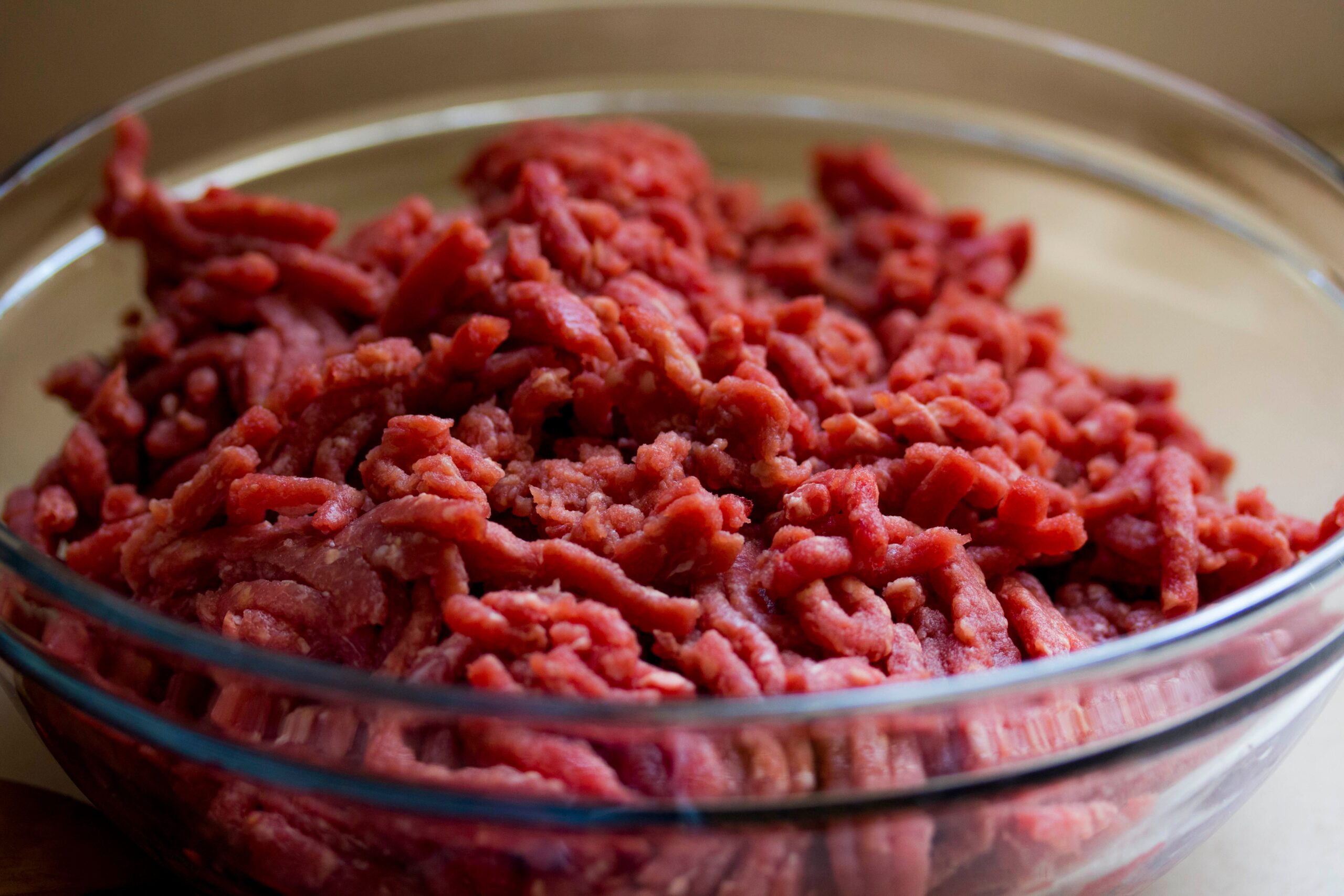 Ground beef in a bowl ready for thawing, with a measuring portion visible