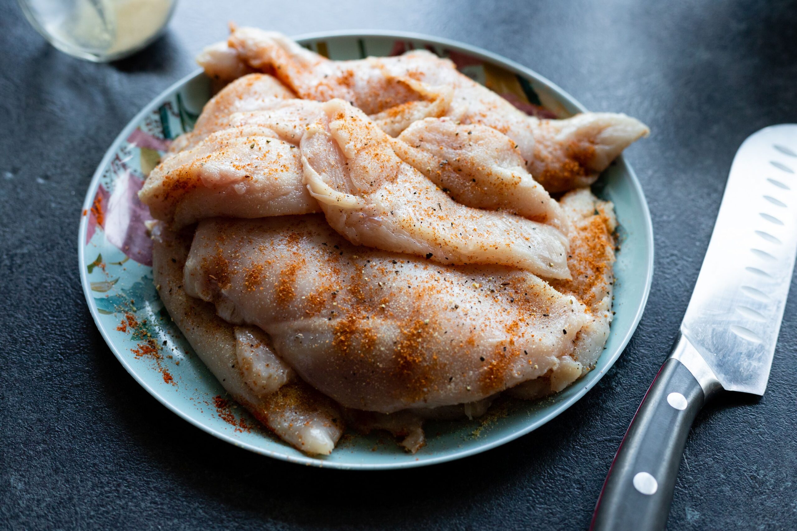 Raw chicken pieces prepared for safe refrigerator defrosting in a dish