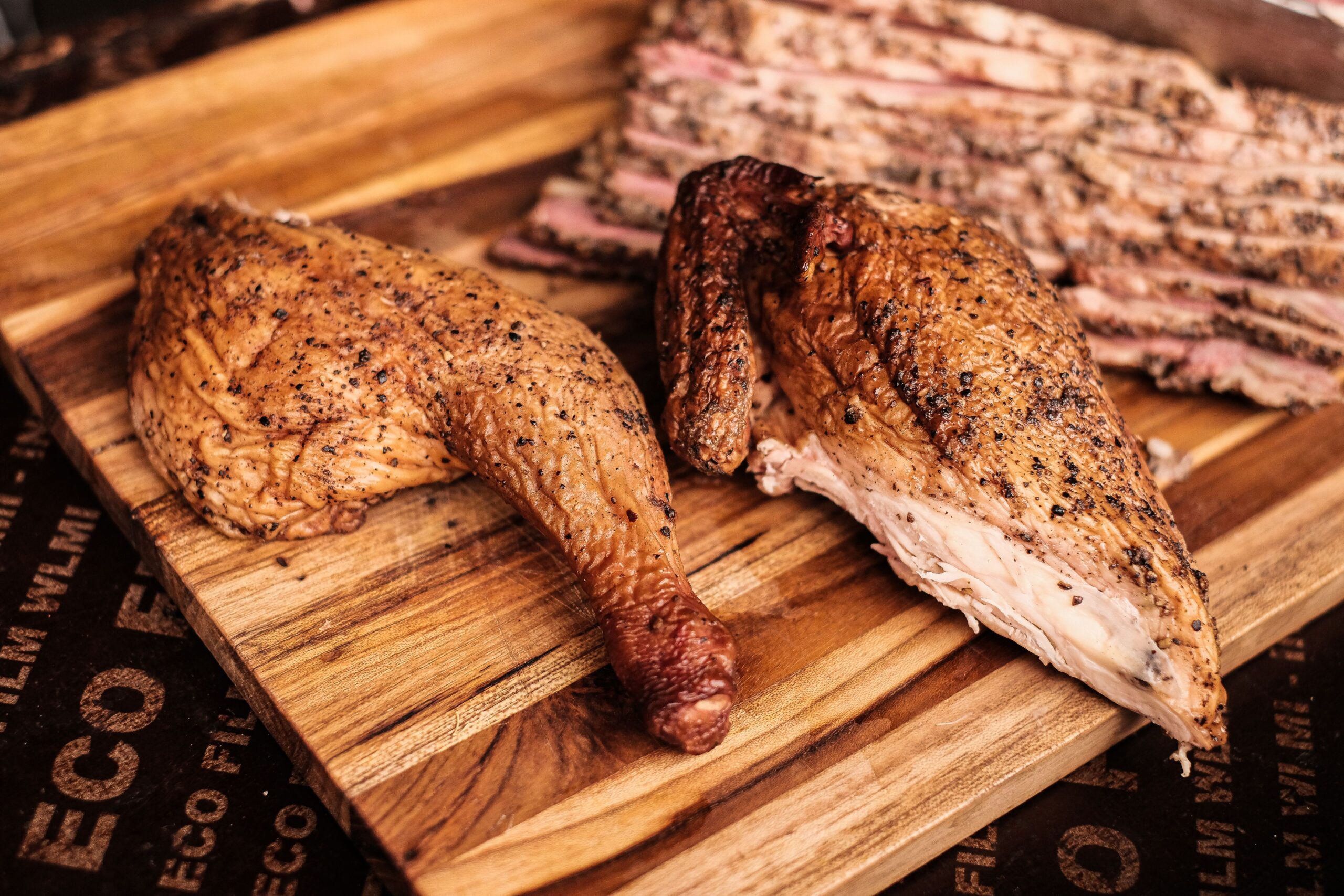 Sliced baked chicken breast on a cutting board showing a moist interior