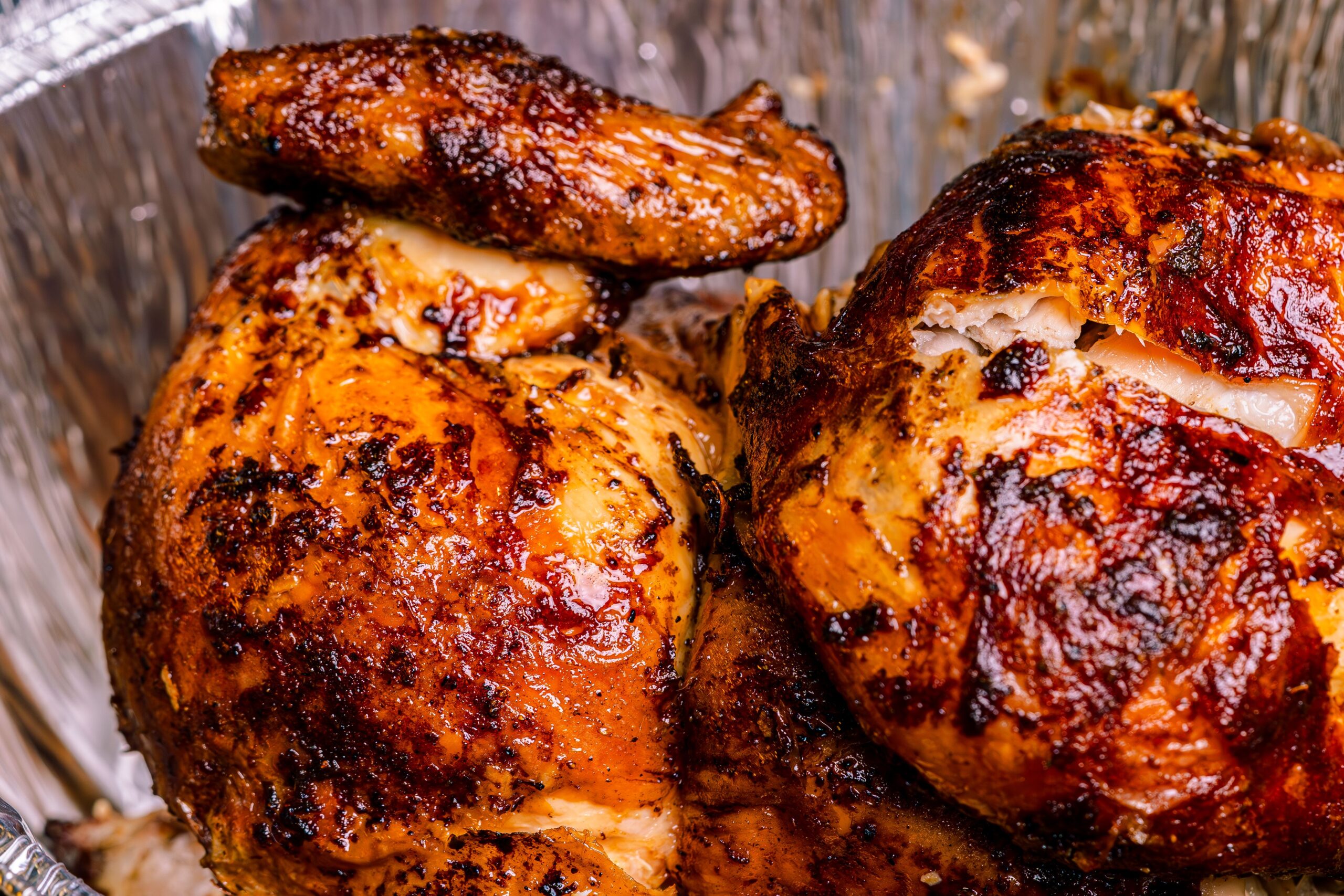 Golden brown whole roasted chicken in a roasting pan fresh from the oven